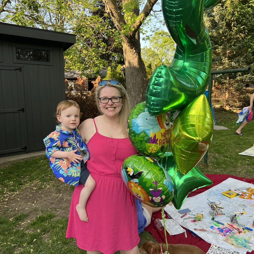Dr. Perchaluk smiling with her young son at a backyard celebration