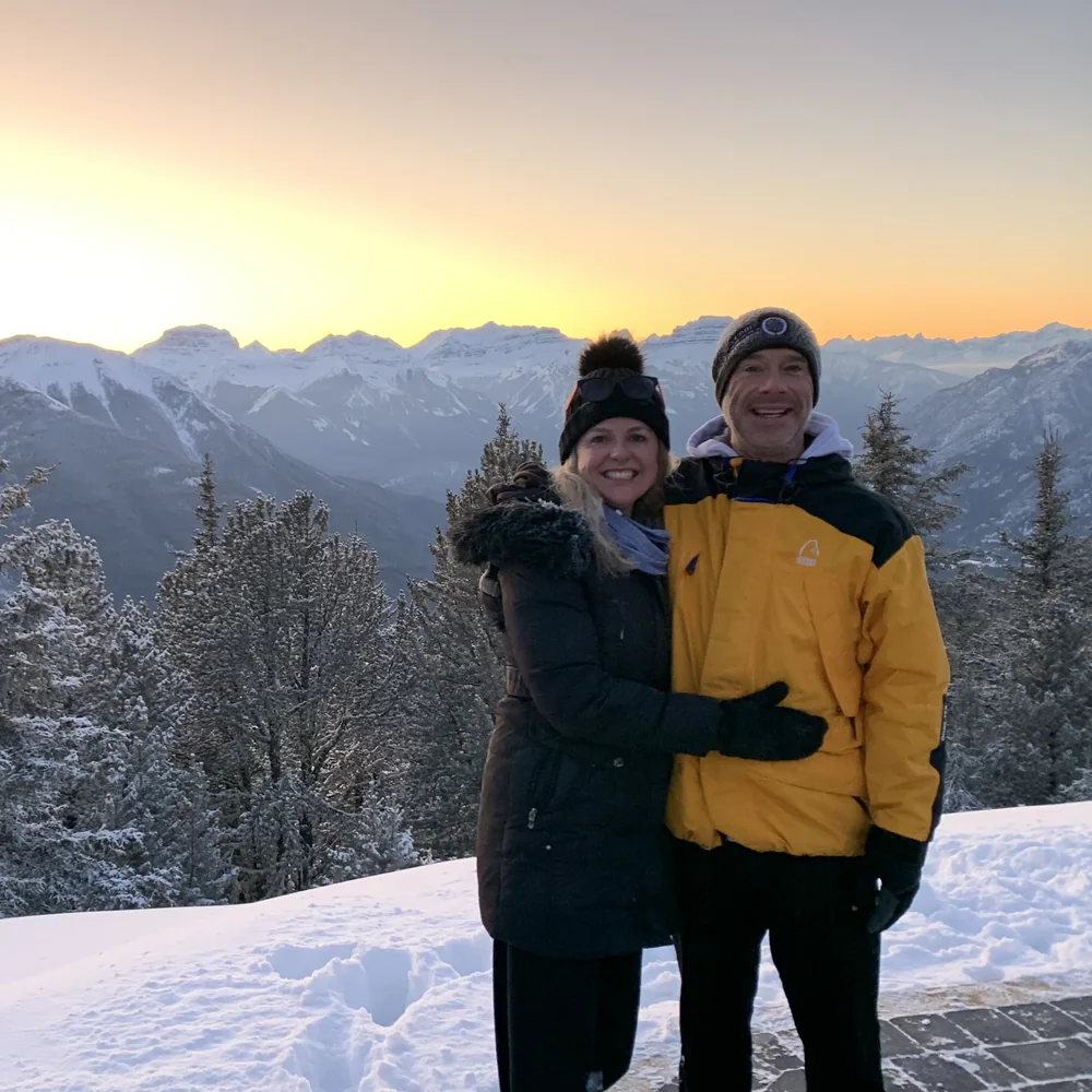 Dr. Perchaluk and her partner in the snowy mountains at sunset